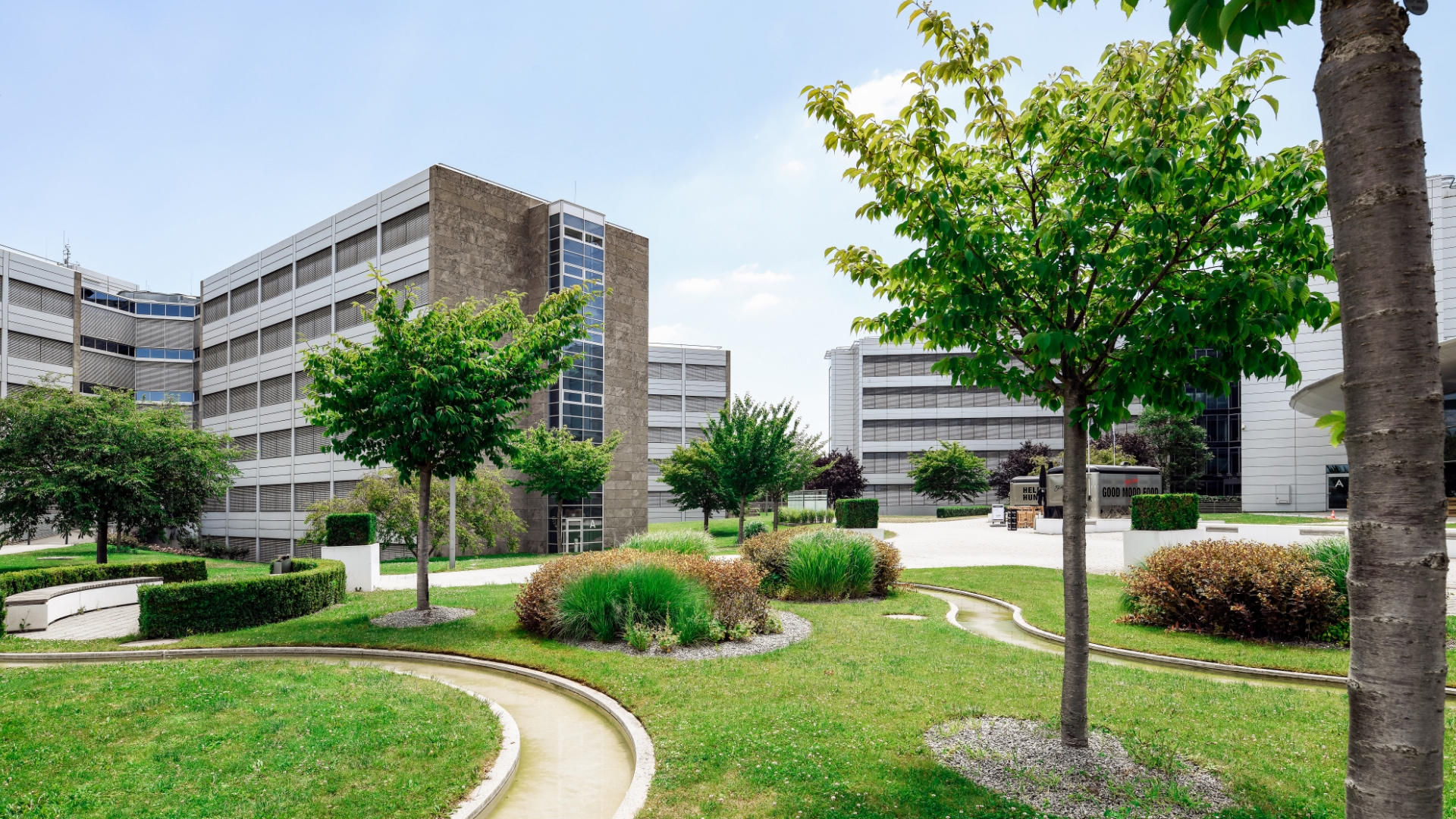 Blick auf die Grünanlagen eines Unternehmens in Wiesloch mit kleinem Wasserlauf